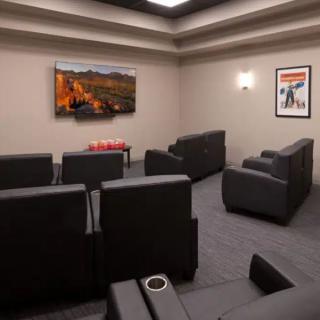 A modern home theater with comfortable seating and a large television.