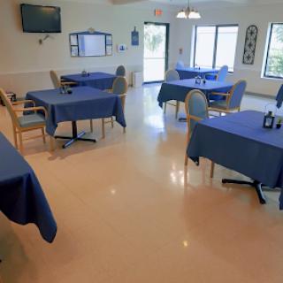 A spacious dining area with blue tablecloths on the tables, creating a calm and inviting atmosphere.