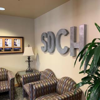 A welcoming lobby area featuring comfortable seating and the SDCH sign.