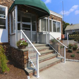 A small business entrance with stairs and a green awning.