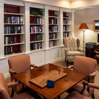Cozy library room with bookshelves and a seating area.