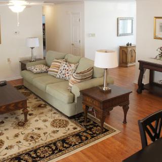A cozy living room setup featuring a comfortable sofa, decorative pillows, a coffee table, and stylish lamps.
