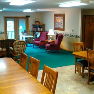 A cozy living room with chairs, a large table, and decorative elements.