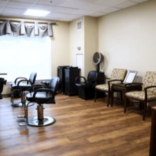 A modern hair salon interior with styling chairs and a waiting area.