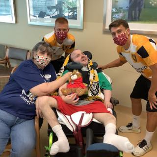 A heartfelt moment shared between caregivers and a loved one in a hospital setting.