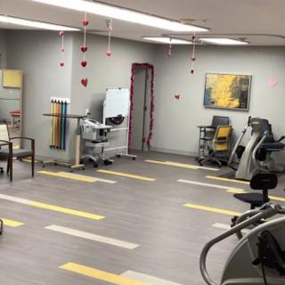 A spacious gym with various exercise equipment and a bright, modern interior design.