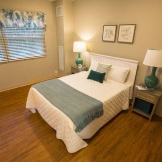 A cozy bedroom with a neatly made bed and elegant decor.