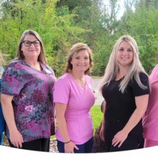 A group of women standing outdoors in casual attire.