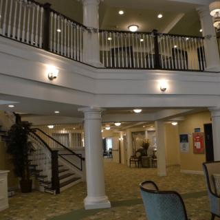 A spacious and elegant lobby with a staircase and classic architectural design.
