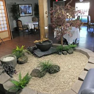 A serene indoor zen garden featuring gravel, decorative stones, and a small water feature.