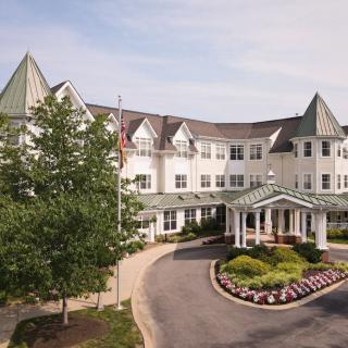 A residential building with a landscaped entrance and circular driveway.
