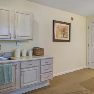 A well-organized kitchen space with light-colored cabinets and a decorative picture on the wall.