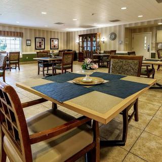 A cozy dining area with several tables and chairs, featuring a warm interior design.
