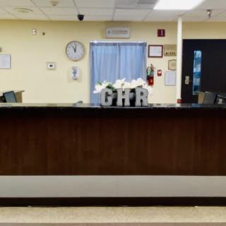 A reception desk in a waiting area with a clock and decorations.