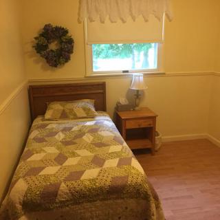 A cozy bedroom with a single bed and simple decor.