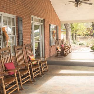 A cozy porch featuring several rocking chairs, inviting relaxation and enjoyment of the outdoors.