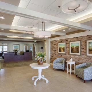 A modern lobby with comfortable seating, decorative lighting, and artwork on the walls.