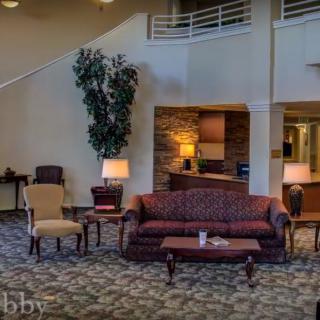A cozy lobby area featuring a sofa, chairs, and warm lighting.