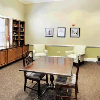 A cozy room with a wooden table, chairs, and a bookshelf.