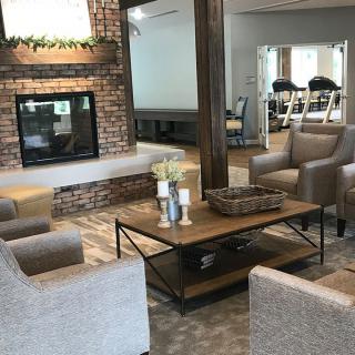 A cozy living room with a stylish seating area surrounding a rustic fireplace.