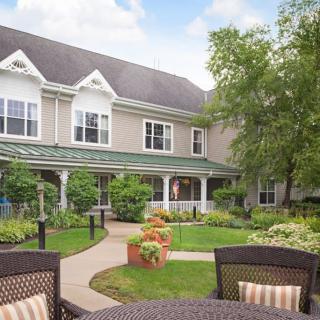 A tranquil garden courtyard with outdoor seating in front of a residential building.