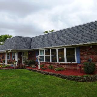 A charming brick house with a well-maintained lawn and landscaping.
