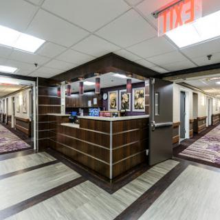 A view of the hotel lobby with a reception desk and hallways leading to guest rooms.