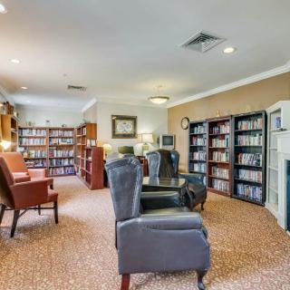 A cozy library room with comfortable armchairs and well-stocked bookshelves.