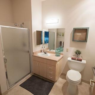 A clean and modern bathroom with a shower, sink, and toilet.