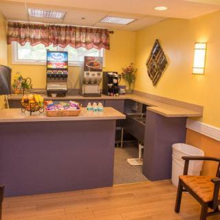 A cozy waiting area with a coffee station and drink machine, complemented by yellow walls and comfortable seating.