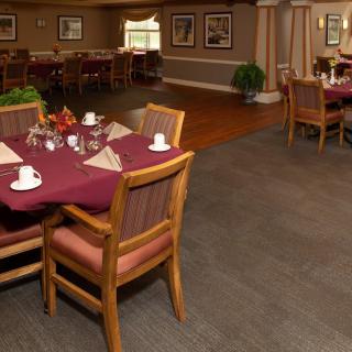 A cozy dining room with neatly arranged tables and chairs, set for service.