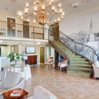 Elegant lobby with a grand staircase and chandelier.