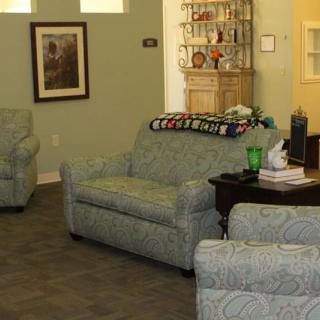 A cozy living room with sofas and armchairs arranged around a coffee table.