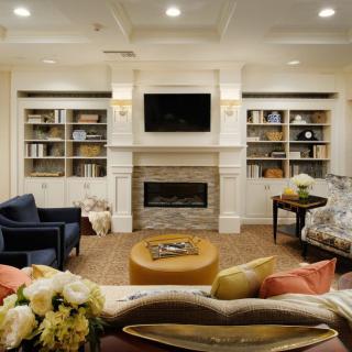 A cozy living room with a fireplace, bookshelves, and comfortable seating.