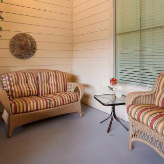 Cozy patio area with striped furniture and a small table featuring a floral arrangement.