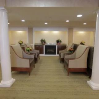 A cozy lobby with elegant seating and a fireplace at the center.