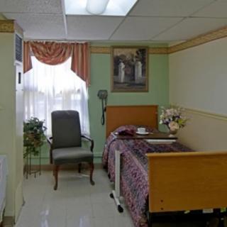 A neatly arranged bedroom with a bed, chair, and decorative elements.