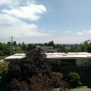 A suburban view with houses, trees, and a cloudy sky.