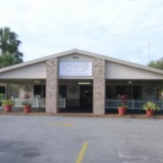 A view of a restaurant entrance with a parking area in front, taken during the day.