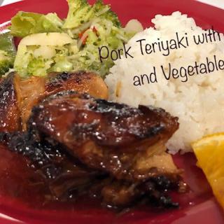 A plate of pork teriyaki served with rice and vegetables.