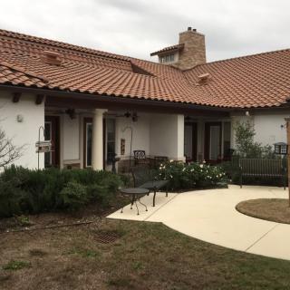 A house with red tile roofing and a courtyard garden.