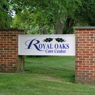 Entrance sign for Royal Oaks Care Center surrounded by greenery.