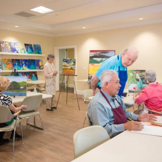 A group of seniors participating in a painting class at a community center.