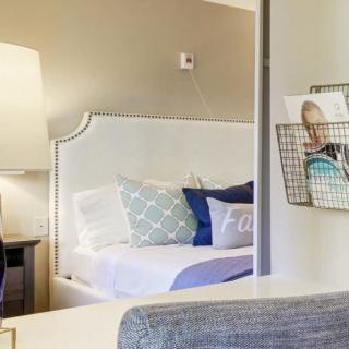 A cozy and well-decorated bedroom with a stylish lamp and comfortable bed.