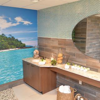 A serene spa bathroom featuring a calming nature mural and elegant wooden features.