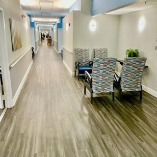 A modern and brightly lit hallway with a set of chairs arranged along one side.