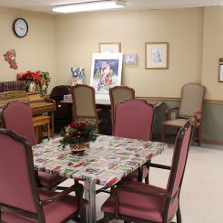 A cozy indoor dining area featuring a table with chairs, decorative elements, and artwork on the walls.