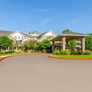 A residential building with landscaped surroundings and a circular driveway.