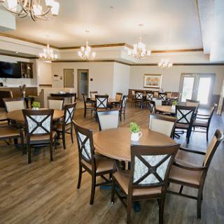 A well-lit dining area featuring elegant furniture and decorative chandeliers.