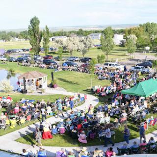 A vibrant community gathering in a park, featuring families and friends enjoying the outdoors.